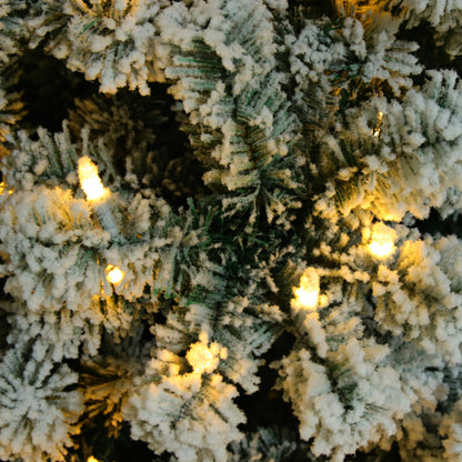 Close-up of flocked artificial Christmas tree branches with warm white LED lights
