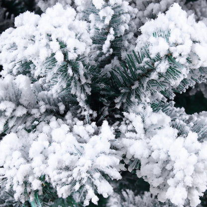 Close-up of flocked artificial Christmas tree branches covered in white snow-like flocking