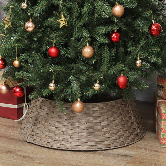 Christmas tree with red and gold ornaments standing on wicker tree collar on wooden floor