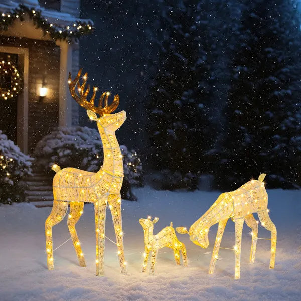 Three-piece lighted reindeer family set with warm white LED lights in snowy outdoor holiday setting