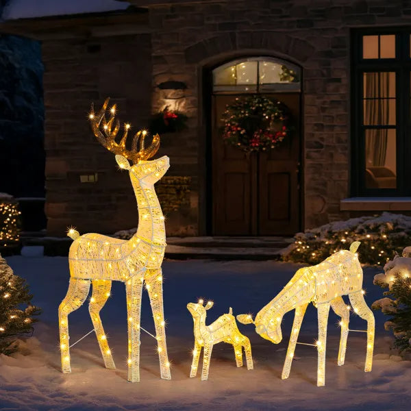 Lighted reindeer family set with 280 warm white LED lights in snowy front yard holiday display