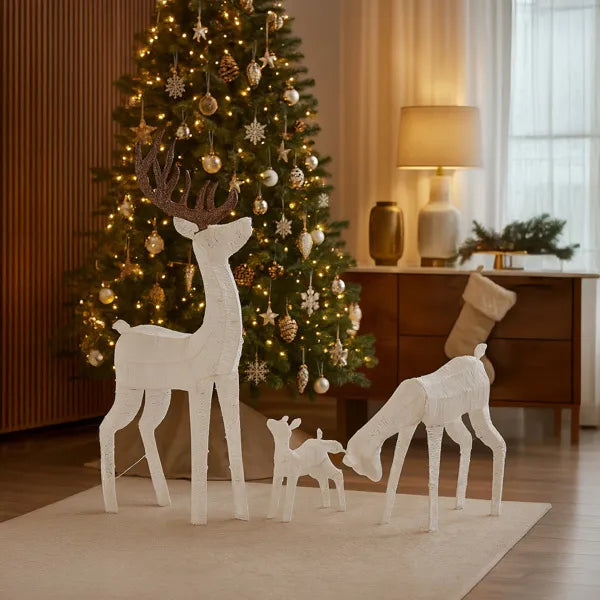 Lighted reindeer family set with warm white LED lights in cozy living room with Christmas tree