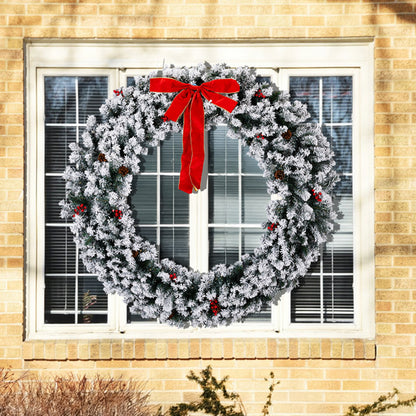 60-inch snow flocked Christmas wreath with red bow and berries on a house window
