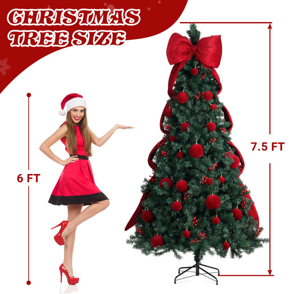 7.5 ft artificial Christmas tree decorated with red ornaments and large bow, woman in red dress and Santa hat stands next to it