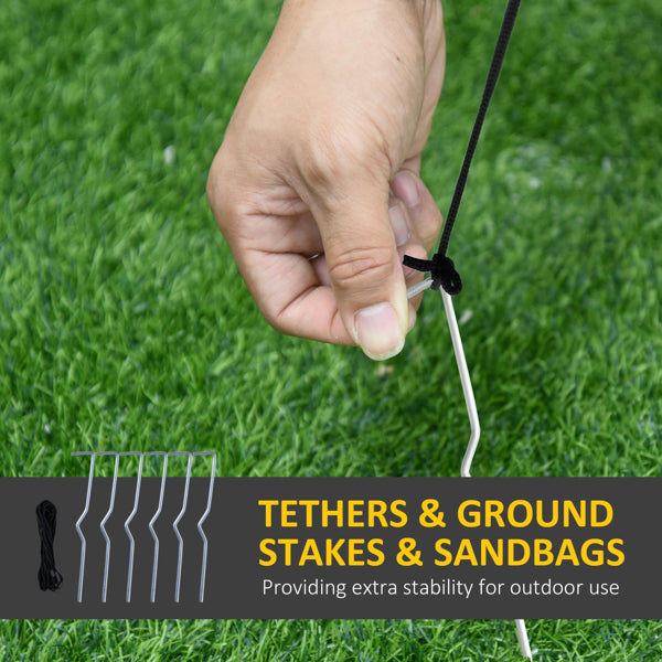 Hand securing a ground stake tether on green grass for outdoor stability of decorations