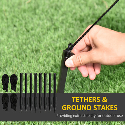 Hand inserting black ground stake into grass with black tether ropes, outdoor stability kit