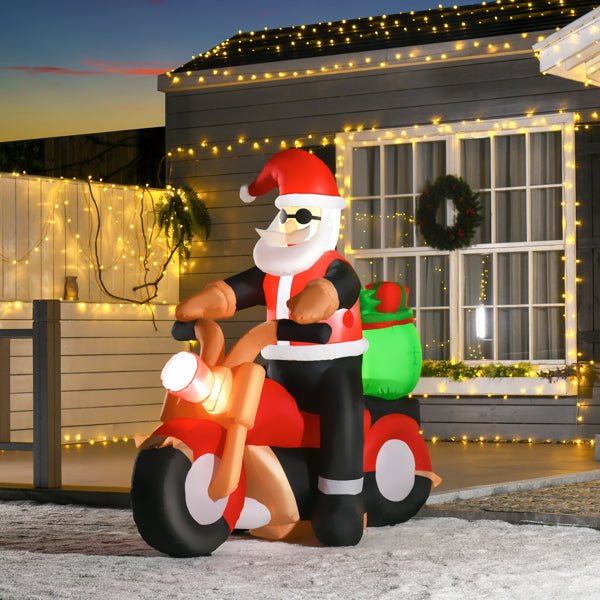 Inflatable Santa Claus on red motorcycle with green sack, outdoor Christmas decoration with house lights
