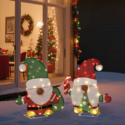Outdoor Christmas decorations featuring two lighted gnome figures with candy cane and festive hats on snowy patio