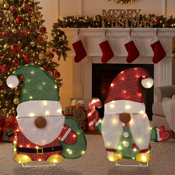 Lighted Christmas gnome decorations with candy cane and gift bag in festive living room with tree and stockings