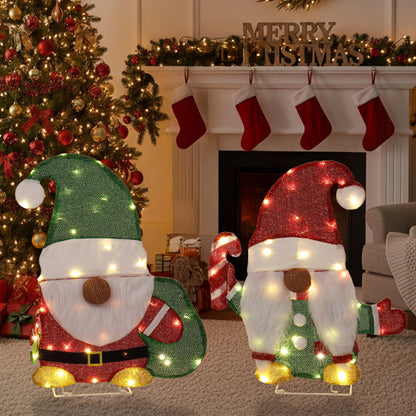 Lighted Christmas gnome decorations with candy cane and gift bag in festive living room with tree and stockings