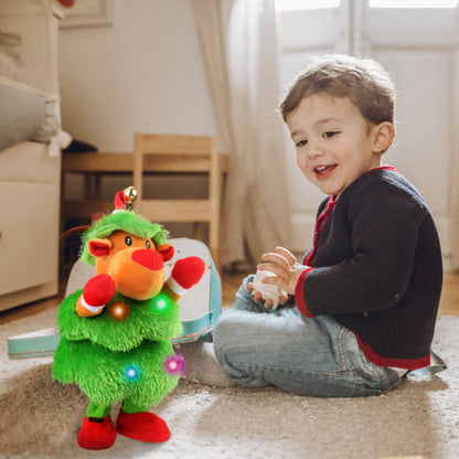 Child sitting on floor smiling, playing with a colorful dancing and singing plush reindeer toy with lights