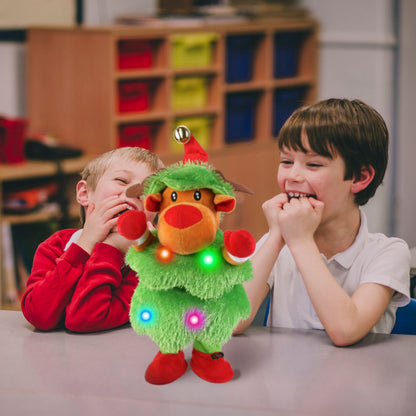 Two children laughing at a talking, dancing plush toy dressed as a Christmas tree with colorful lights