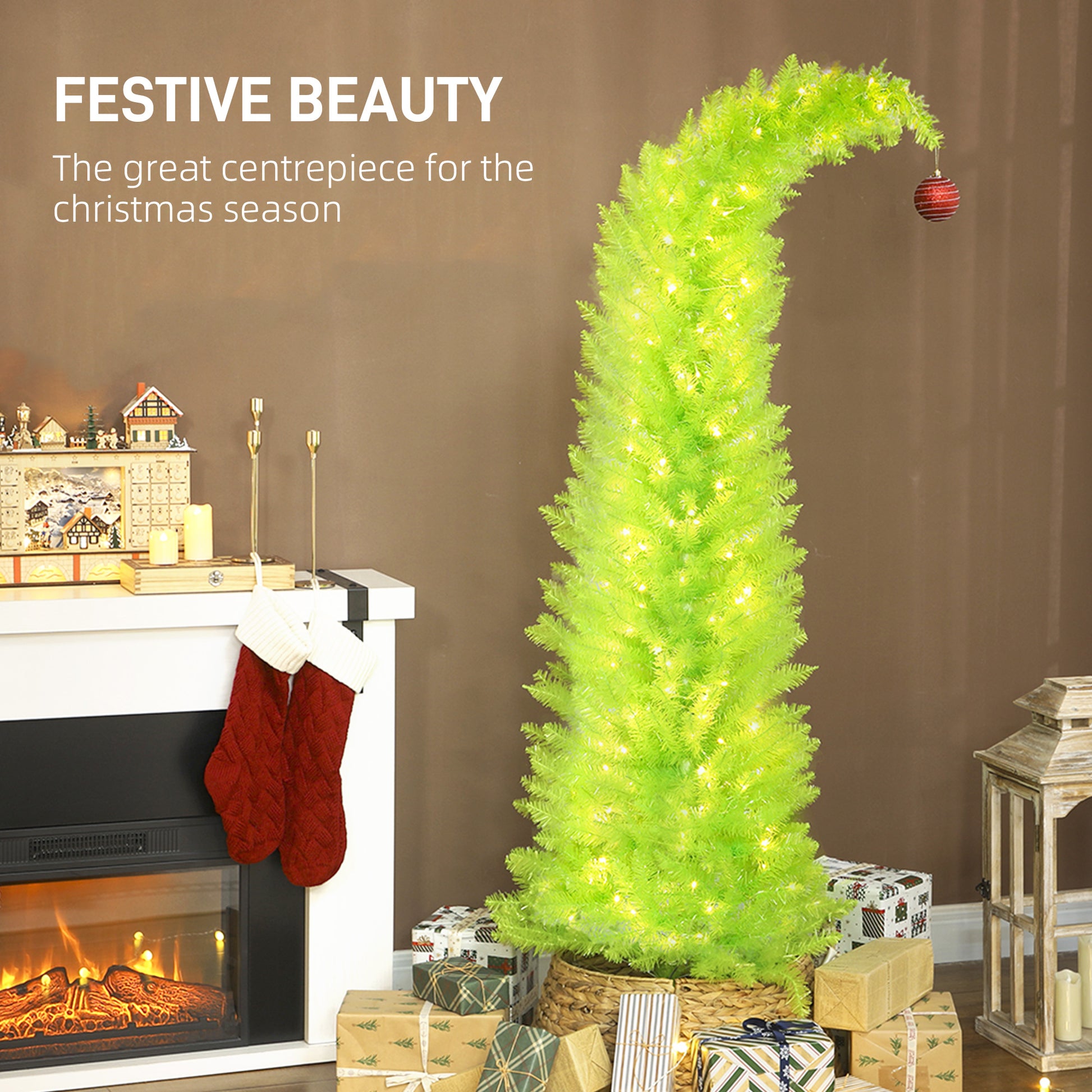 Slim green pre-lit whimsical Christmas tree with stocking, gifts, and fireplace