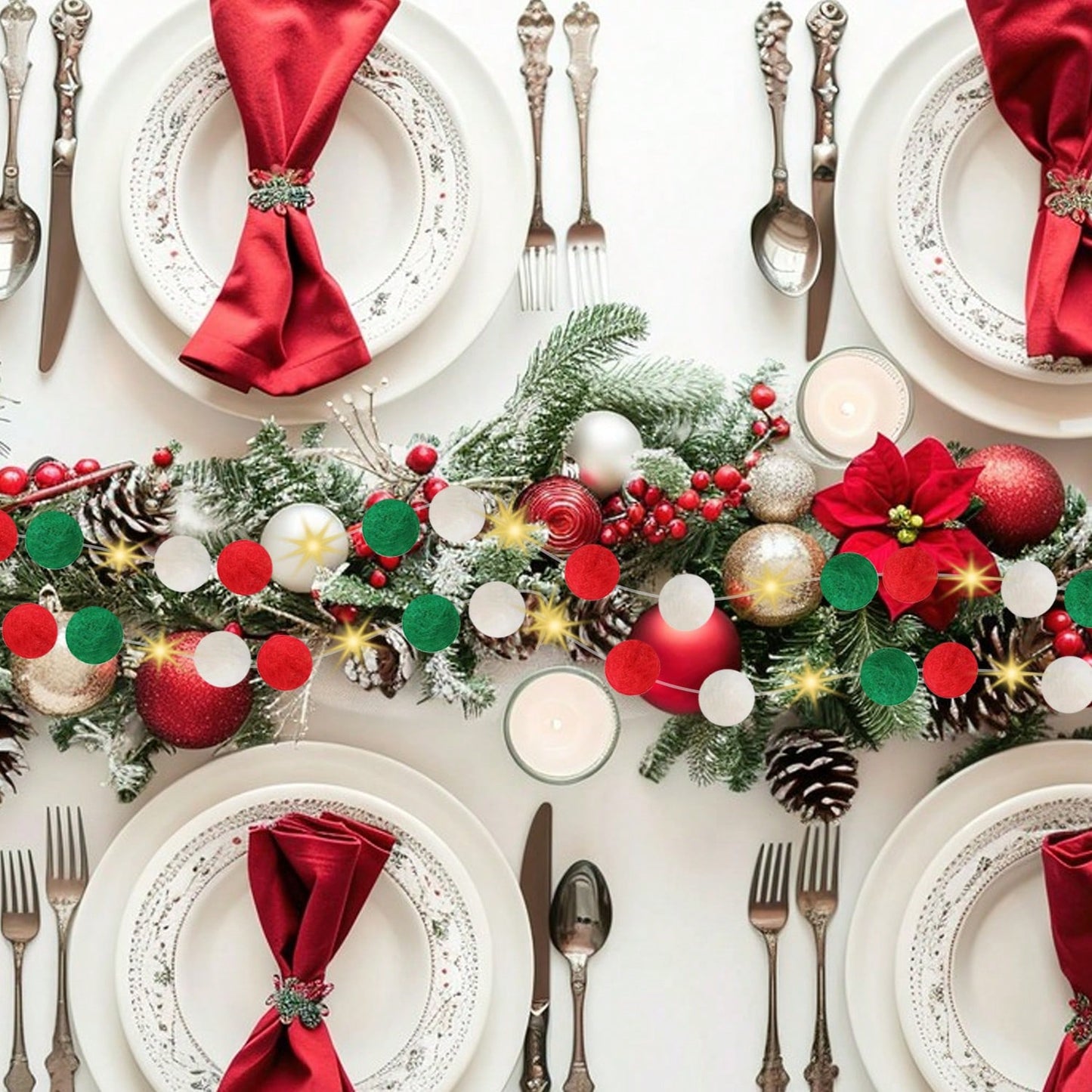 Elegant Christmas table setting with red napkins, vintage silverware, pinecone centerpiece, and festive garland