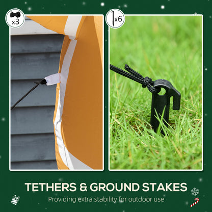 Close-up of black ropes tethered to an orange inflatable and a black ground stake in green grass for outdoor stability