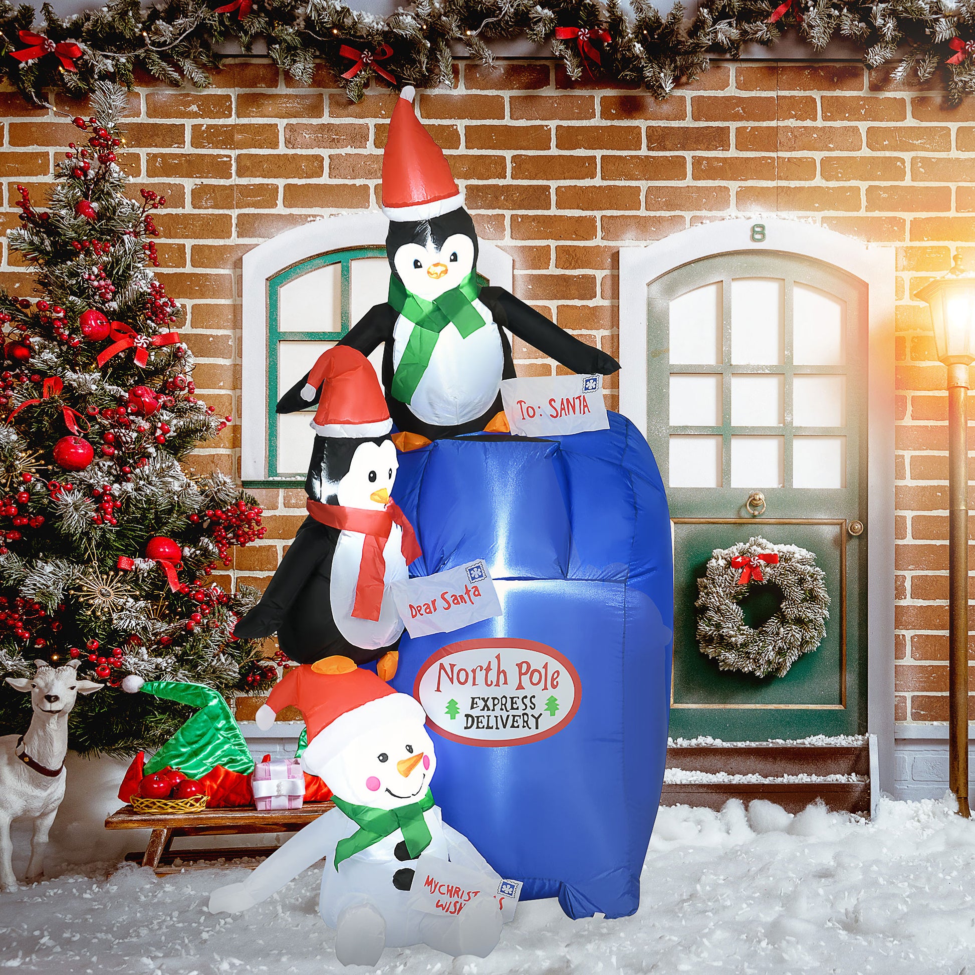 Christmas inflatable display with penguins and snowman placing letters in North Pole Express mailbox