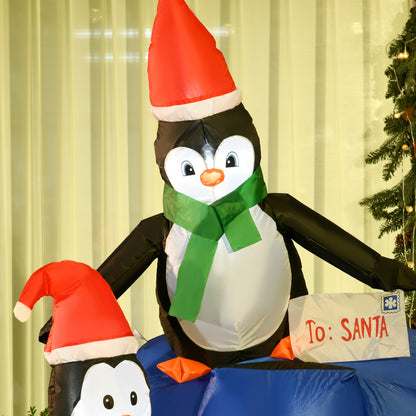 Inflatable Christmas penguins with Santa hats, one holding a letter addressed To: Santa