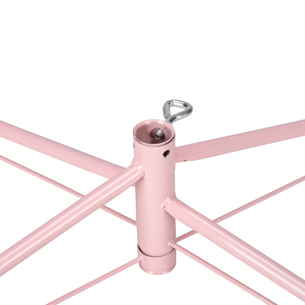 Close-up of pink metal Christmas tree stand with central locking mechanism and support bars