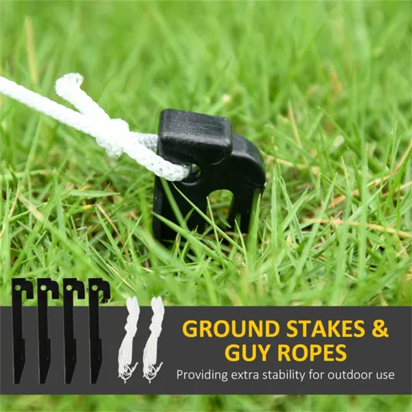Set of black ground stakes with white guy ropes on green grass for outdoor stability