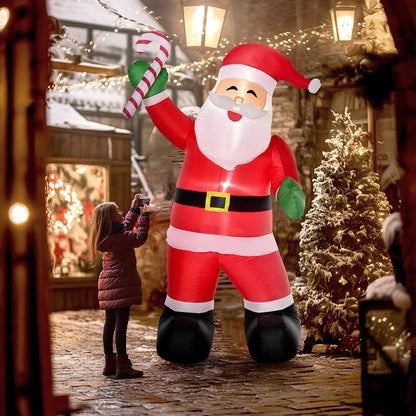 8ft inflatable Santa Claus decoration holding candy cane on snowy cobblestone street with Christmas lights