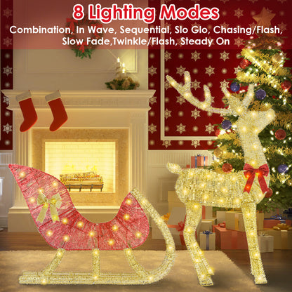 Lighted Christmas reindeer with red bow and sleigh decorated with gold ribbon in cozy living room