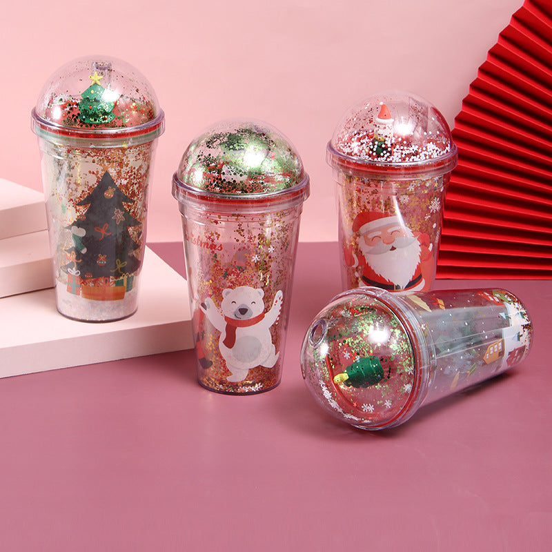 Set of four Christmas-themed reusable cups with dome lids featuring Santa, polar bear, Christmas tree, and festive designs with glitter