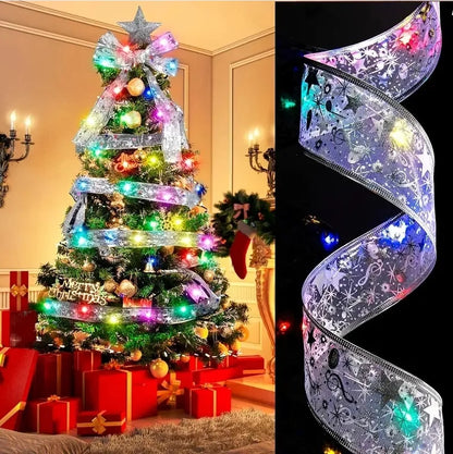 Decorated Christmas tree with silver mesh ribbon, colorful lights, gold ornaments, star topper, and red gift boxes