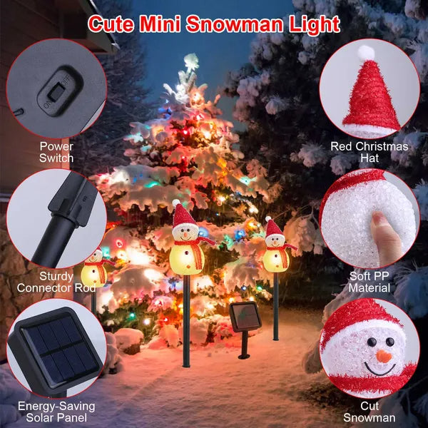 Outdoor solar-powered mini snowman stake lights with red hats and warm white LED glow in snowy garden