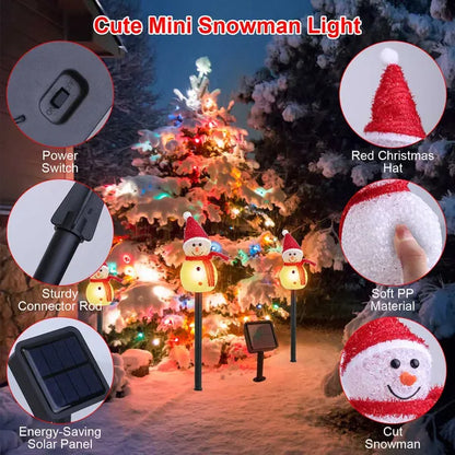 Outdoor solar-powered mini snowman stake lights with red hats and warm white LED glow in snowy garden