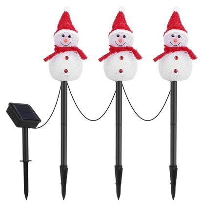 Three solar-powered snowman stake lights with red hats and scarves connected by black wiring