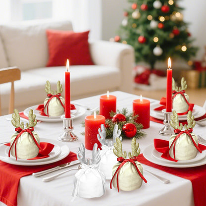Christmas dining table with red candles and fabric gift bags decorated with golden and silver reindeer antlers