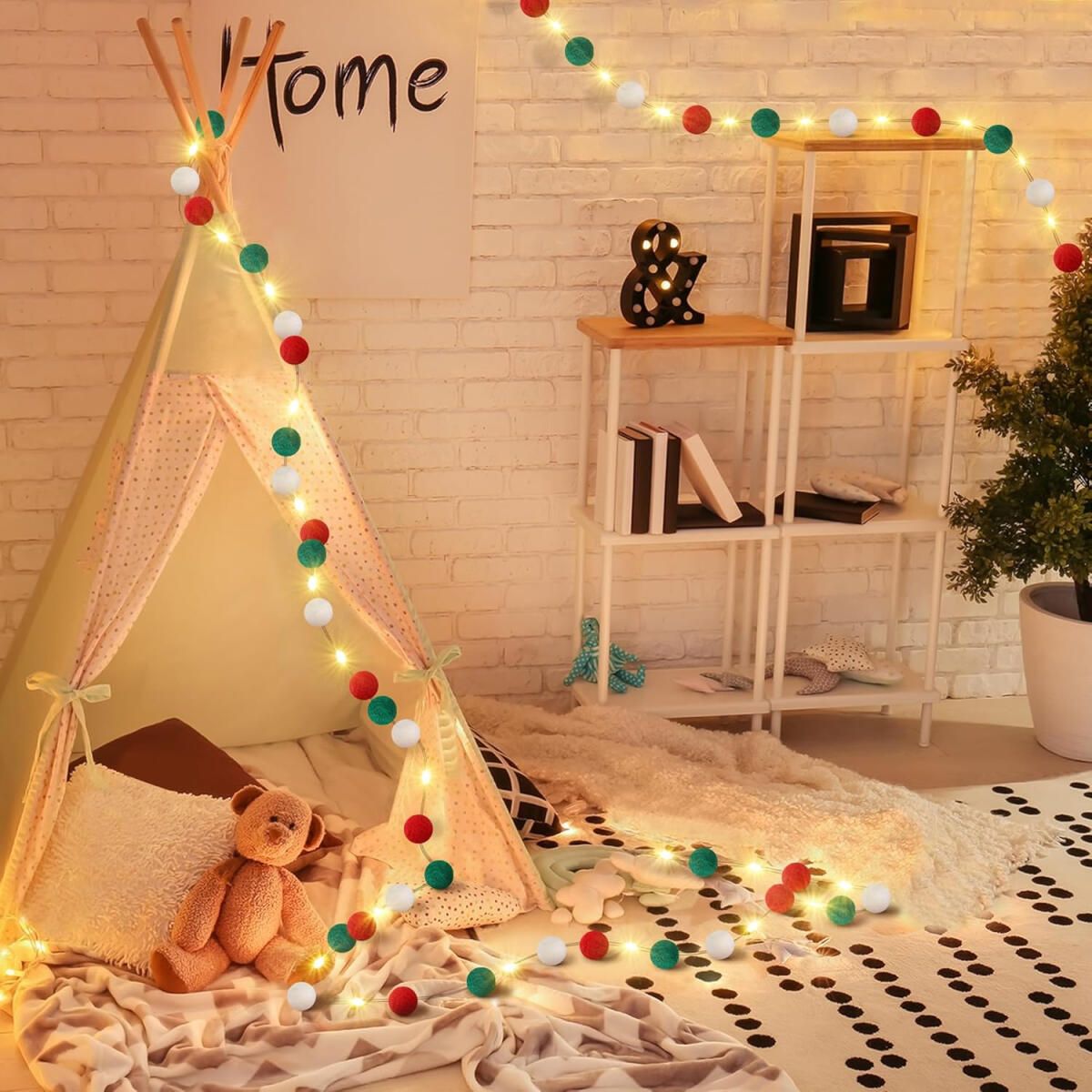 Cozy kids playroom with teepee tent, teddy bear, warm white string lights, and red-green-white felt ball garland