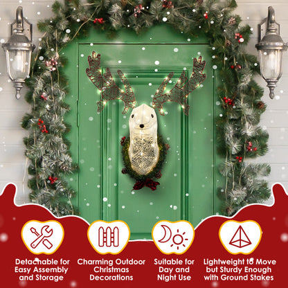 Lighted reindeer head Christmas decoration with warm white LED lights on green door framed by festive garland