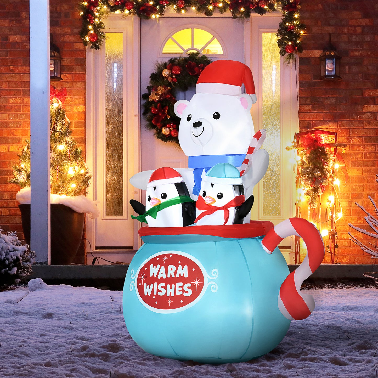 Inflatable Christmas decoration of polar bear and two penguins in blue cup with candy cane and warm wishes text