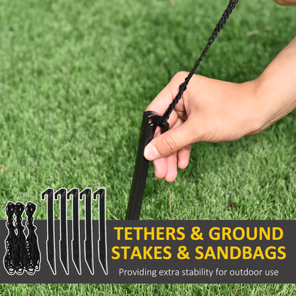 Hand holding a black ground stake with tether rope on green grass, outdoor stability tools