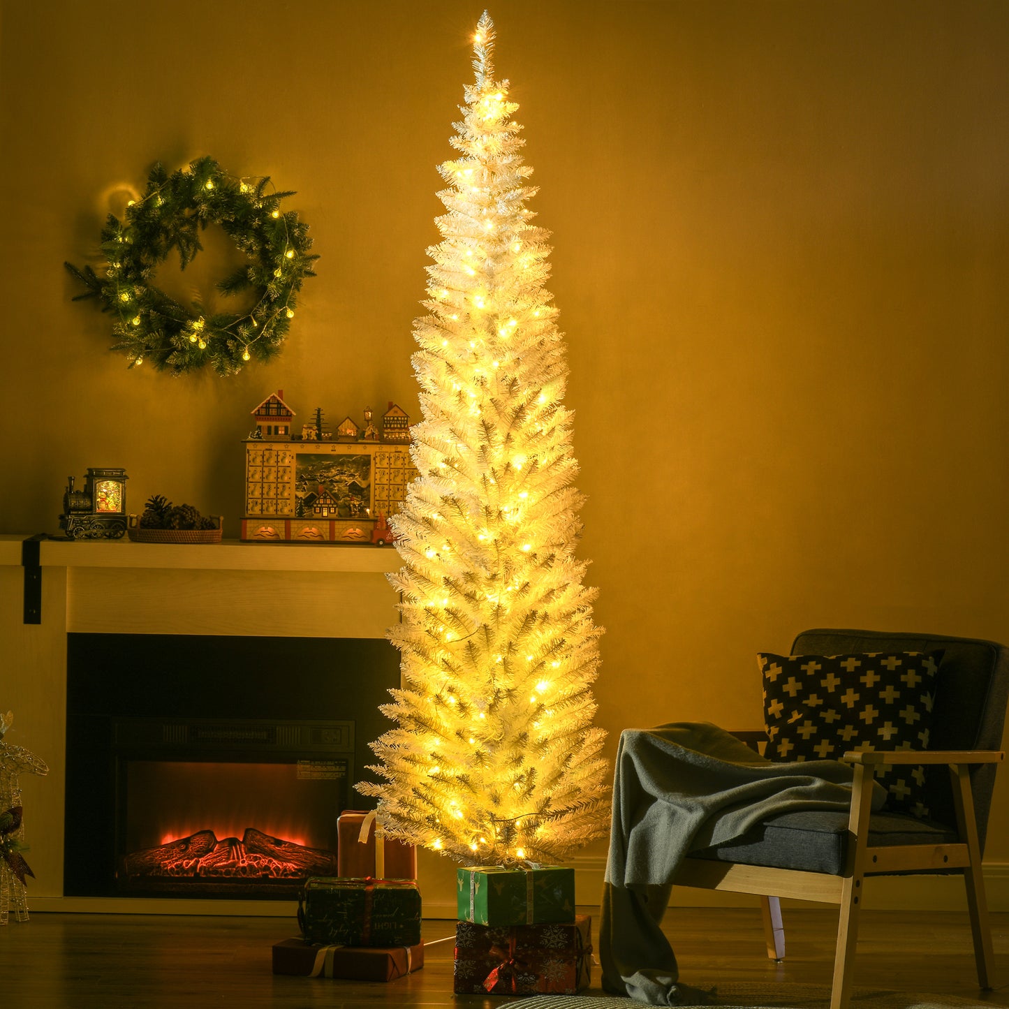 Slim white artificial Christmas tree with warm white LED lights near fireplace and cozy armchair