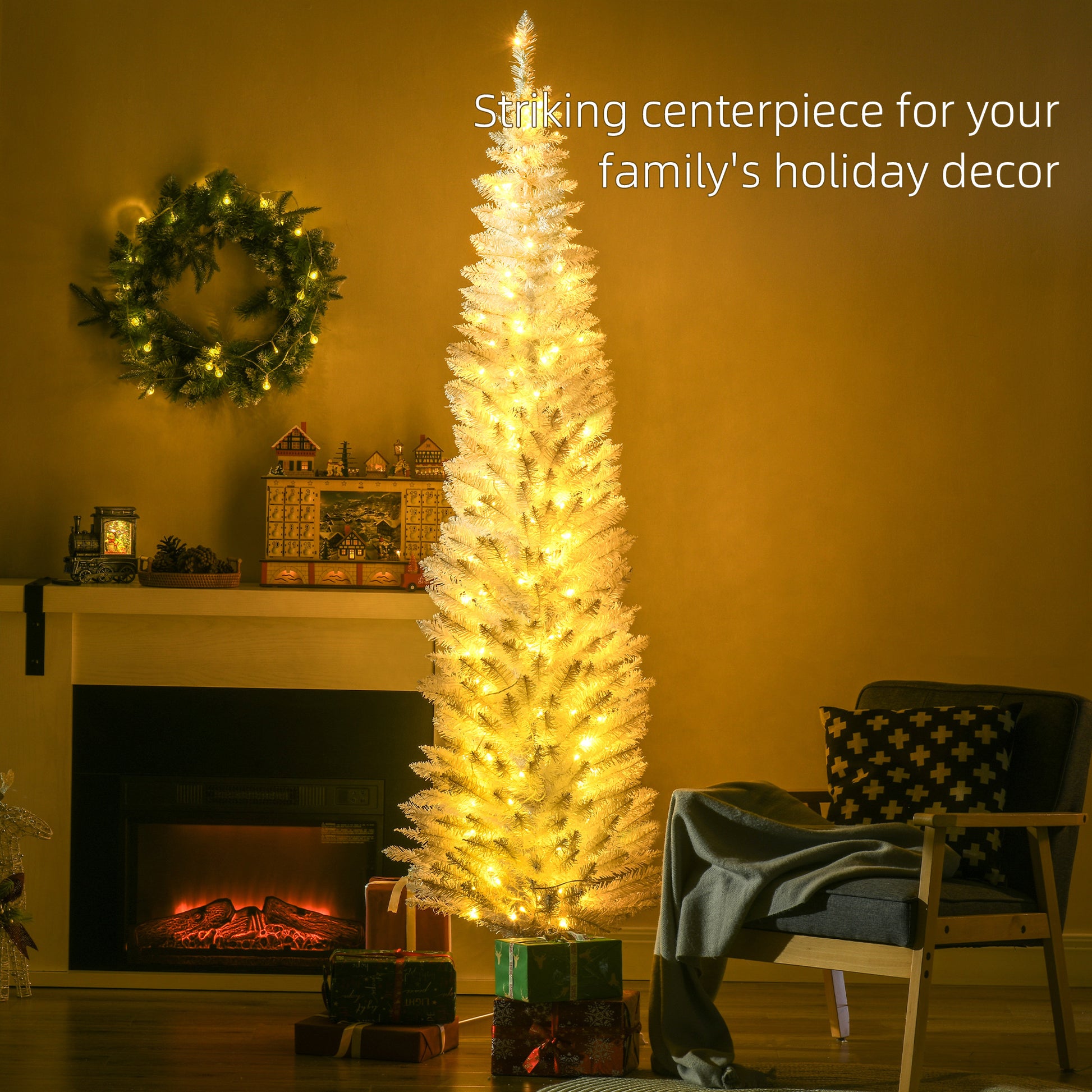 White pencil Christmas tree with warm white LED lights by a fireplace, decorated holiday wreath and cozy armchair