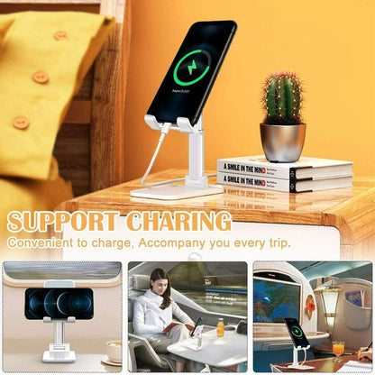White foldable adjustable phone stand on wooden table with smartphone charging, cactus, books, and travel scenes