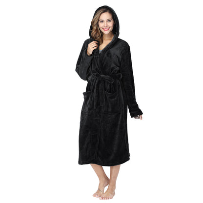 Smiling woman wearing black plush fleece hooded robe with pockets and belt on white background